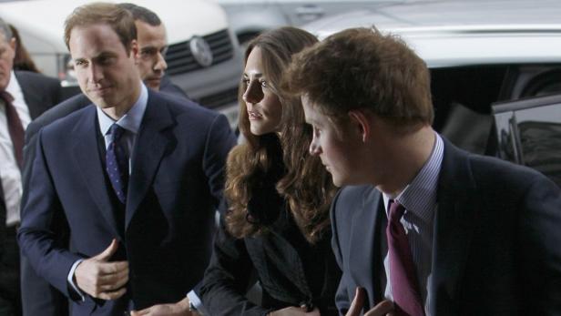 Prinz William, Kate Middleton und Prinz Harry verlassen ein Gebäude.
