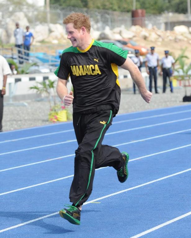 Prinz Harry läuft auf einer blauen Laufbahn in einem T-Shirt mit der Aufschrift „Jamaica“.