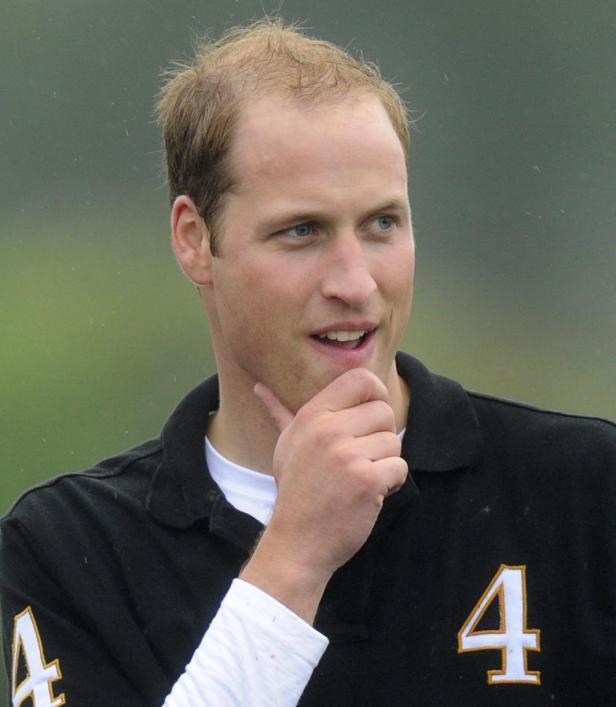Prinz William in einem schwarzen Poloshirt mit der Nummer 4 nachdenklich.