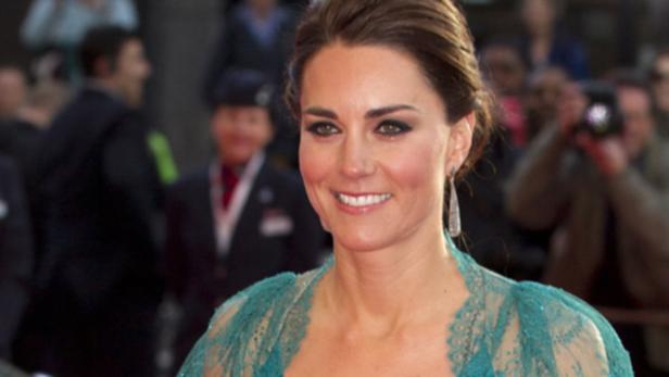 Catherine, Princess of Wales, lächelt in einem türkisfarbenen Kleid.