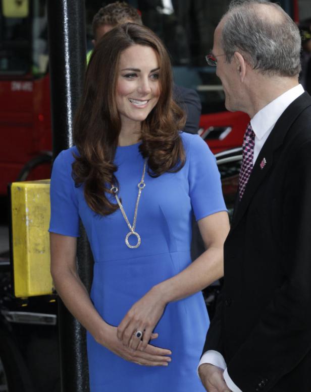 Catherine, Prinzessin von Wales, in einem blauen Kleid im Gespräch mit einem Mann.