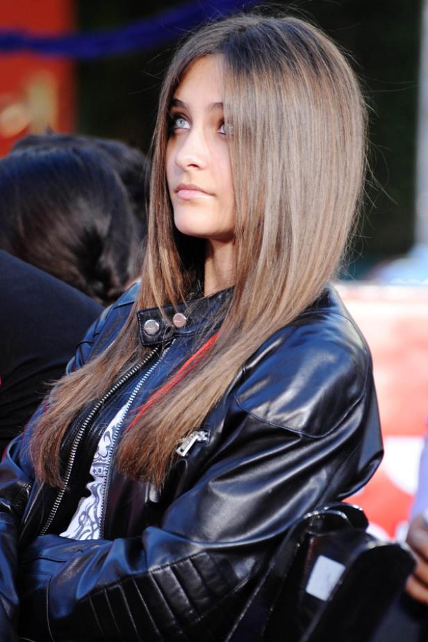 Paris Jackson mit hellbraunen Haaren und Lederjacke blickt zur Seite.