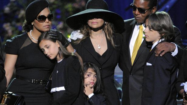 Mitglieder der Familie Jackson stehen zusammen bei einer Veranstaltung.