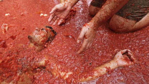 Ein Mann liegt während der Tomatina-Schlacht in Buñol, Spanien, in einer Masse aus Tomaten.