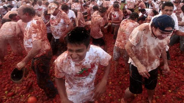 Menschen nehmen an der Tomatina, einer Tomatenschlacht, teil.