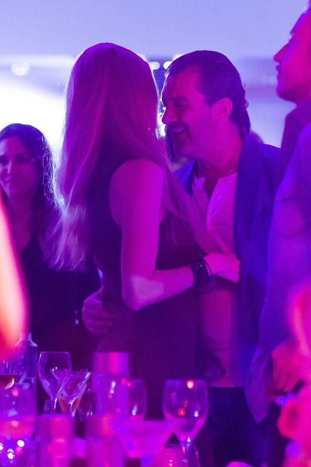 Ein Mann umarmt eine Frau auf einer Party mit violetter Beleuchtung.
