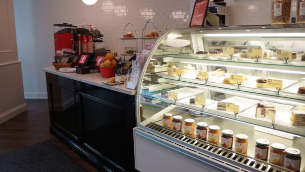 Ein Café mit einer Theke voller Kuchen, Marmeladen und Getränke.