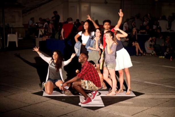 Eine Gruppe junger Leute posiert auf einem Platz für ein Foto.