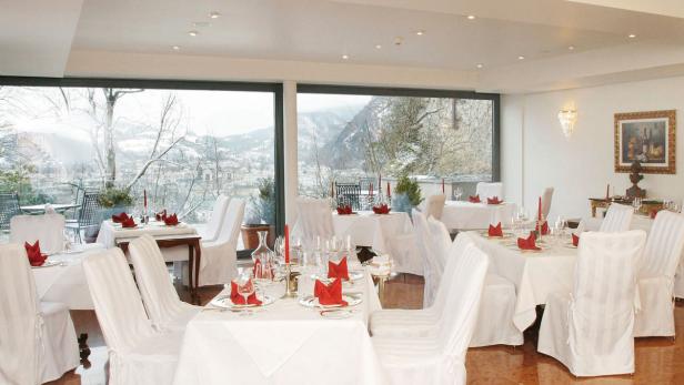 Ein elegant gedeckter Tisch in einem Restaurant mit Blick auf eine verschneite Landschaft.