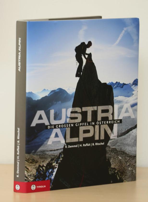 Das Buch „Austria Alpin – Die großen Gipfel in Österreich“ zeigt einen Bergsteiger auf einem Gipfel.