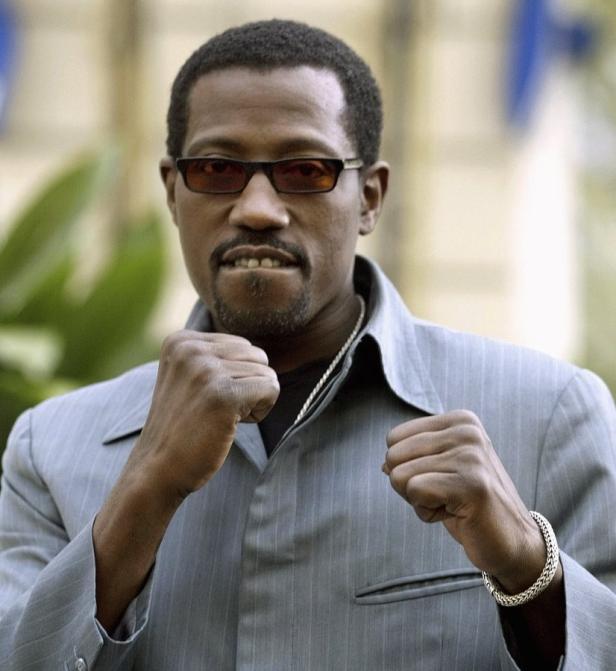 Wesley Snipes posiert mit geballten Fäusten für ein Foto.