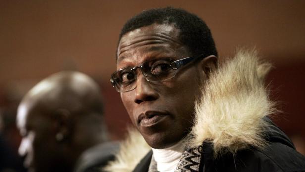 Wesley Snipes mit Brille und Winterjacke mit Fellkragen.