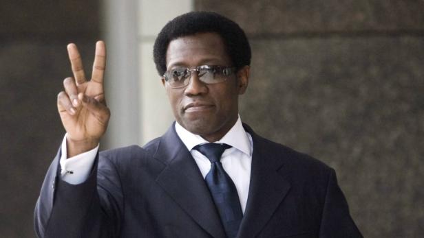 Wesley Snipes im Anzug mit Brille zeigt das Victory-Zeichen.