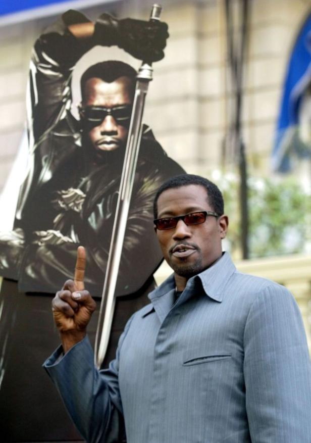 Wesley Snipes posiert vor einem „Blade“-Filmposter.
