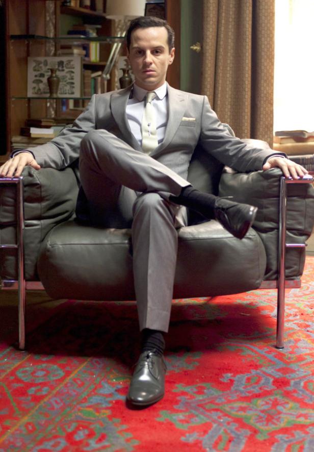 Andrew Scott sitzt in einem grauen Anzug in einem Sessel.