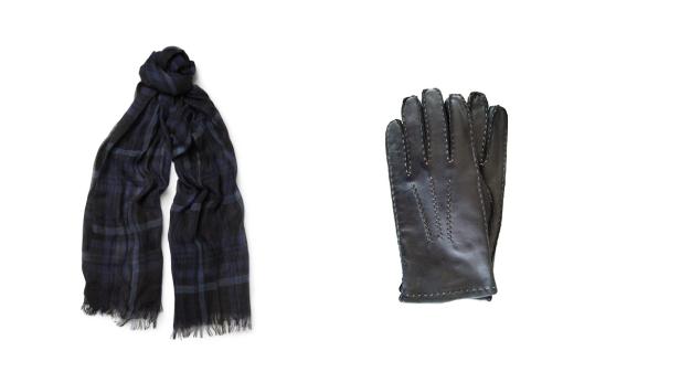Ein karierter Schal und ein Paar Lederhandschuhe liegen auf einem weißen Hintergrund.