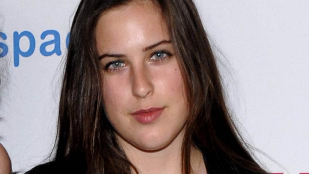 Nahaufnahme einer jungen Frau mit braunem Haar und blauen Augen.