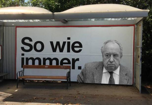 Ein Bushaltestellen-Werbeplakat zeigt den Schriftzug „So wie immer.“ und das Porträt eines Mannes.