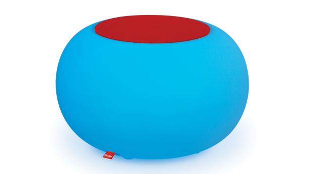 Ein runder, türkisblauer Hocker mit einer roten Sitzfläche auf einem weißen Hintergrund.