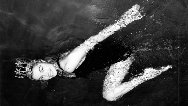 Eine Frau mit Krone schwimmt im Wasser.