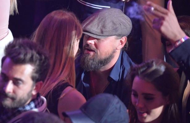 Leonardo DiCaprio unterhält sich mit einer Frau auf einer Veranstaltung.