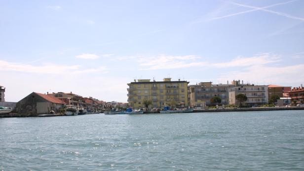 Blick auf eine Küstenstadt mit Booten im Wasser.