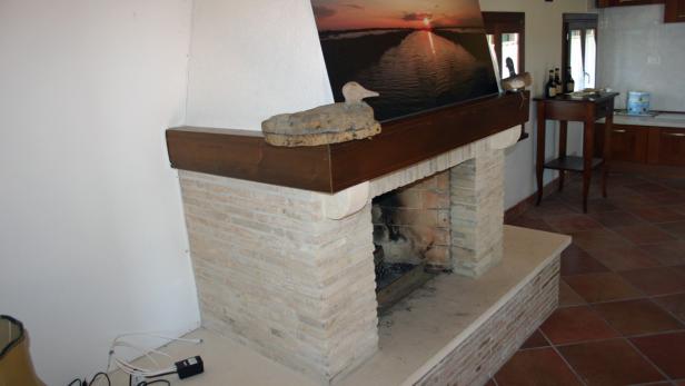 Ein Kamin mit einem hölzernen Entenornament und einem Landschaftsbild darüber.