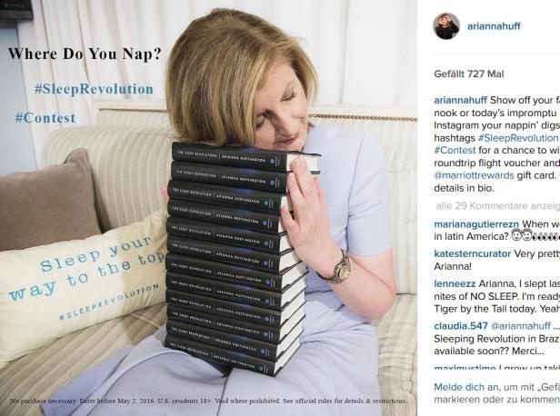 Arianna Huffington umarmt einen Stapel ihrer Bücher „The Sleep Revolution“.