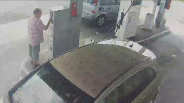 Ein Mann bedient eine Zapfsäule an einer Tankstelle.