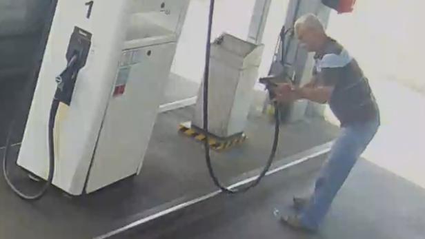 Ein Mann betankt sein Auto an einer Tankstelle.