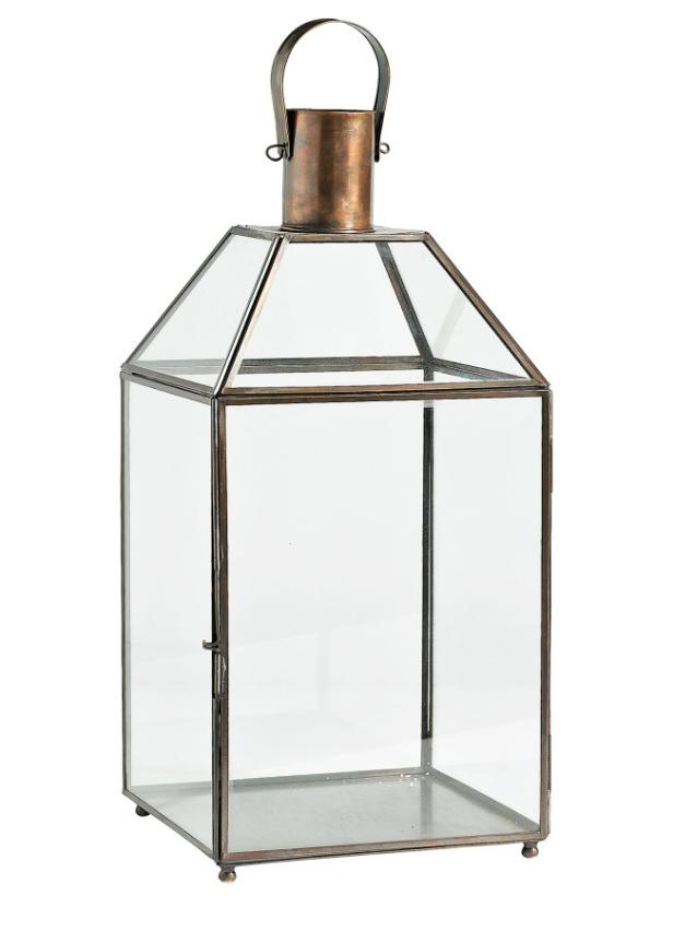 Eine leere, dekorative Laterne aus Glas und Metall steht auf einem weißen Hintergrund.