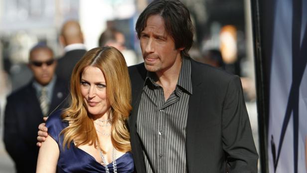 Gillian Anderson und David Duchovny posieren zusammen auf einem roten Teppich.