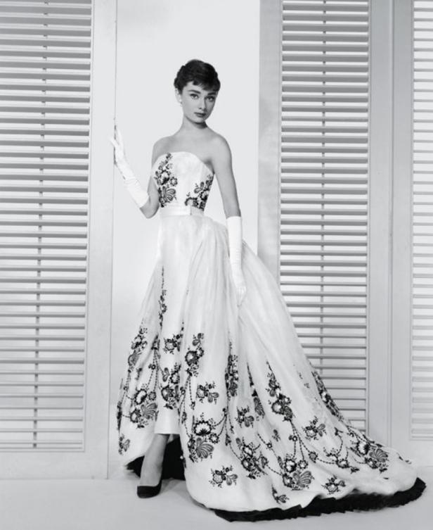Audrey Hepburn in einem eleganten, bodenlangen Kleid mit Blumenmuster.