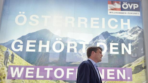 Ein Mann geht an einem Wahlplakat der ÖVP mit dem Slogan „Österreich gehört den Weltoffenen“ vorbei.