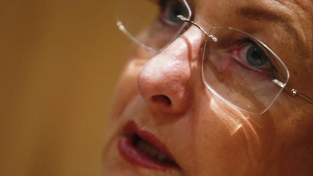 Nahaufnahme des Gesichts einer Frau mit Brille, die nach oben blickt.