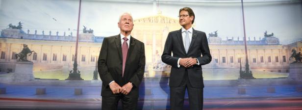 Zwei Männer in Anzügen stehen vor dem Wiener Parlament.