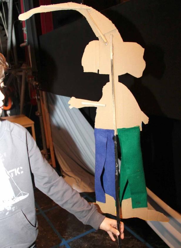 Eine Person hält eine selbstgemachte Marionette aus Pappe und Stoff.