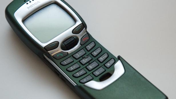 Ein grünes Nokia-Handy mit Tastenfeld liegt auf einem Tisch.