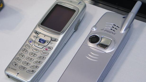 Zwei silberne J-Phone-Mobiltelefone von Sharp, eines mit einer Kamera auf der Rückseite.