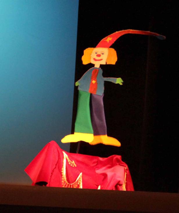 Eine bunte, selbstgemachte Marionette mit einem Clown auf einer Bühne.