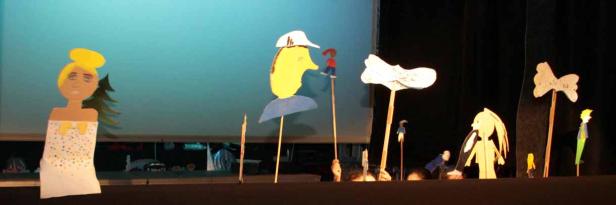 Eine Aufführung mit handgefertigten Marionetten vor einem blauen Hintergrund.