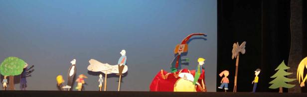 Eine Szene aus einem Marionettentheater mit verschiedenen Figuren und Kulissen.