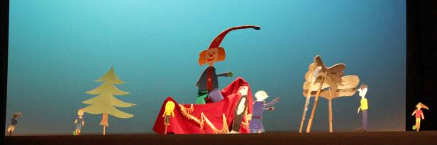 Eine Szene aus einem Marionettentheater mit verschiedenen Figuren und Kulissen.