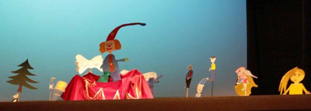 Eine Aufführung mit handgefertigten Marionetten vor einem blauen Hintergrund.