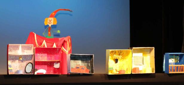 Eine Puppenspielszene mit einem Clown und mehreren Zimmern in Schuhkartons.