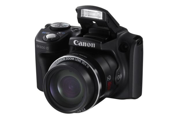 Eine schwarze Canon SX500 IS Kamera mit ausgeklapptem Blitz.