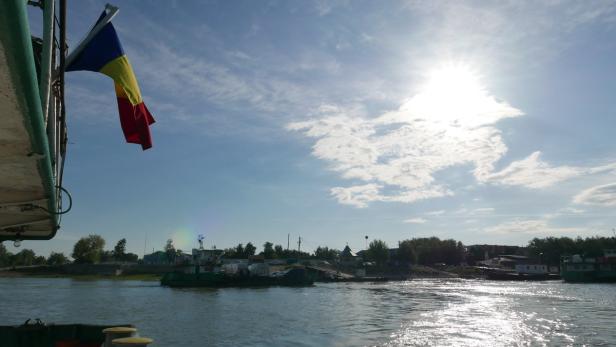 Eine rumänische Flagge weht auf einem Schiff auf der Donau.