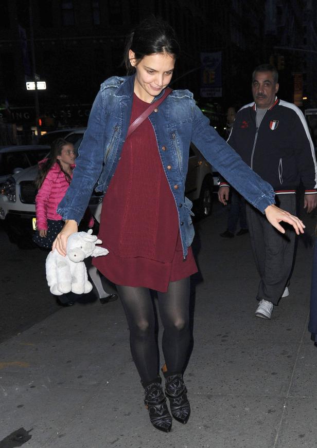 Katie Holmes mit einem Stofftier in der Hand auf der Straße.