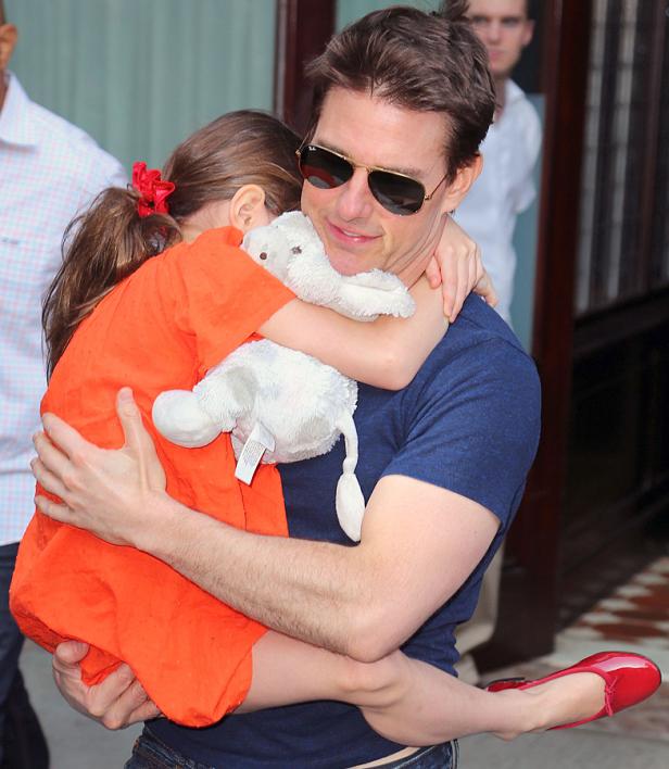 Tom Cruise umarmt seine Tochter, die ein Stofftier hält.