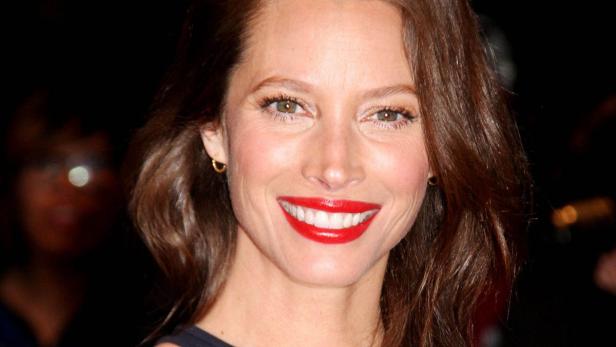 Nahaufnahme von Jessica Biel mit rotem Lippenstift und goldenen Ohrringen.